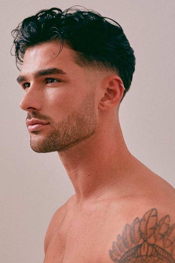 Wavy hair men are a type of hair that grows straight before taking loose curly shapes. Fade, undercut, and slicked back work well.